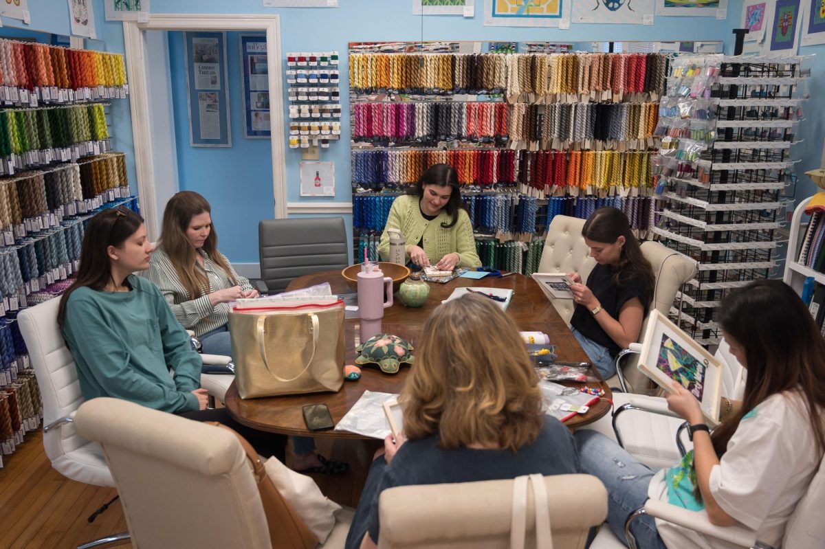 Stitch Social BR members sit together at the Elegant Needle working on their projects and socializing, Monday, March 17, at Stitch Social BR.