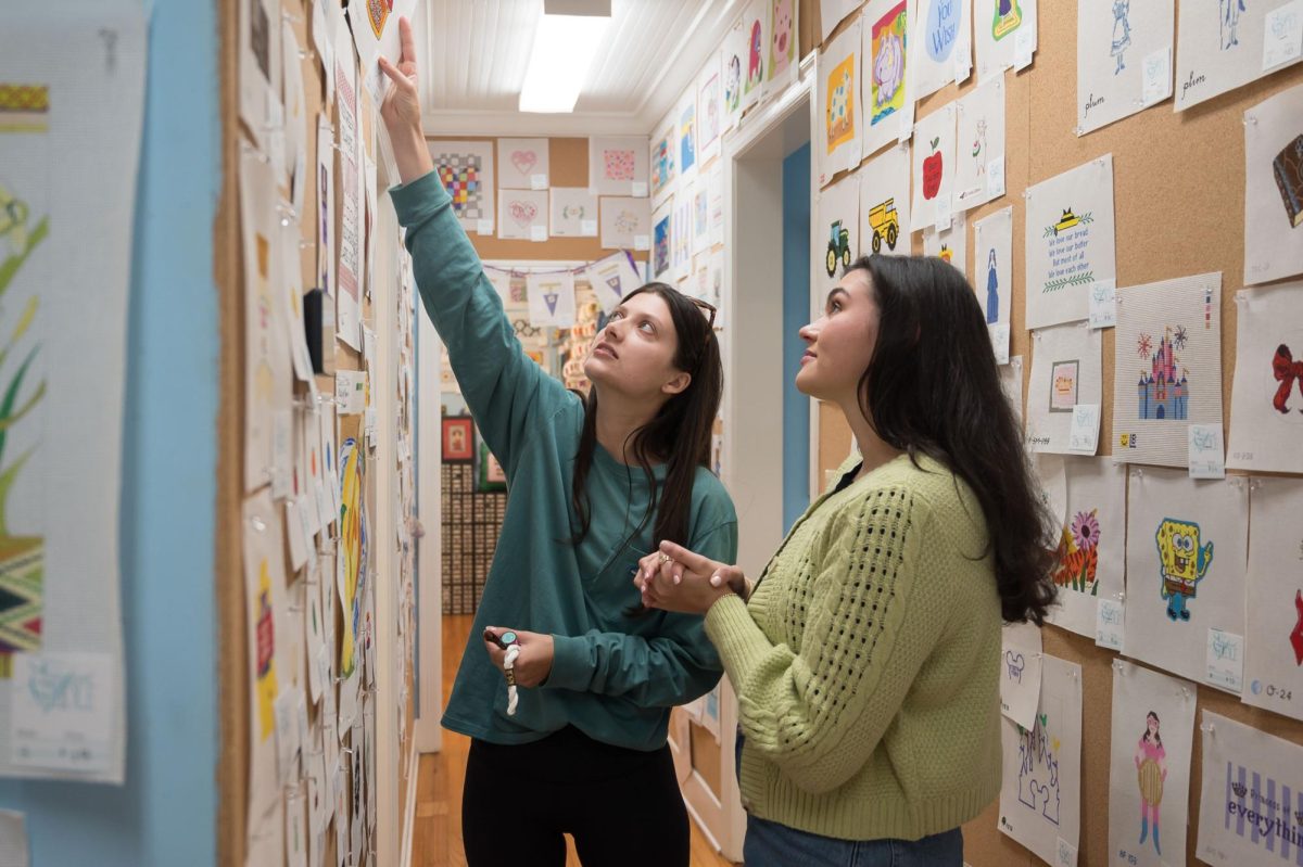 Stitch Social BR co-creator Caroline Cantrelle, right, helps member Rebecca Atkins pick out a new pattern for her latest project, Monday, March 17, at the Elegant Needle.