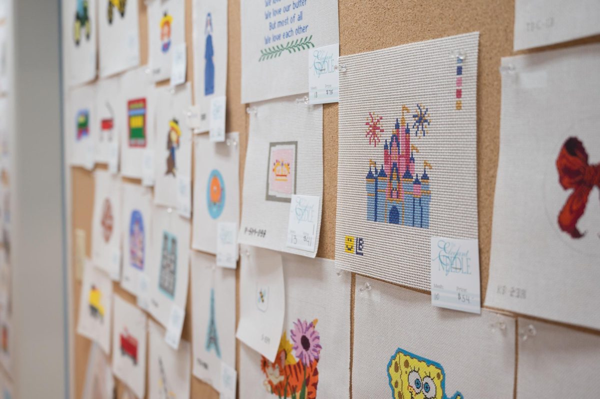 The walls of the Elegant Needle are lined with painted patterns for purchase, featuring various themes and colors. 