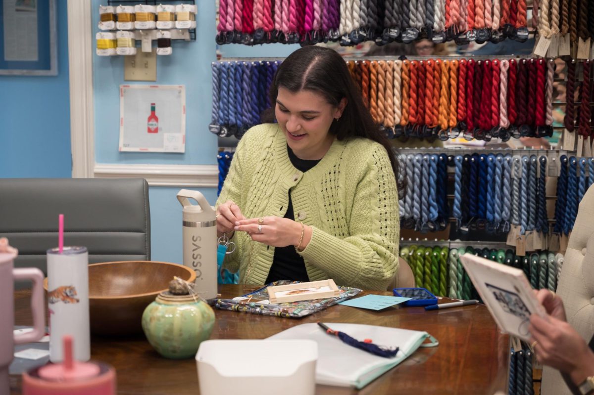 Stitch Social BR co-creator Caroline Cantrelle works on her own project while sitting with other members, Monday, March 17, at the Elegant Needle.